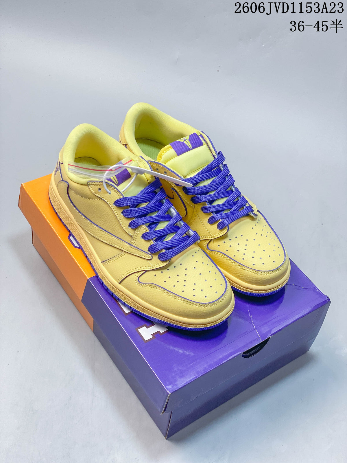 Pair of yellow low-top sneakers with purple laces and contrast detailing.