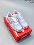 White and pink NikeCourt Borough Low Essential+ sneakers displayed on a red shoebox