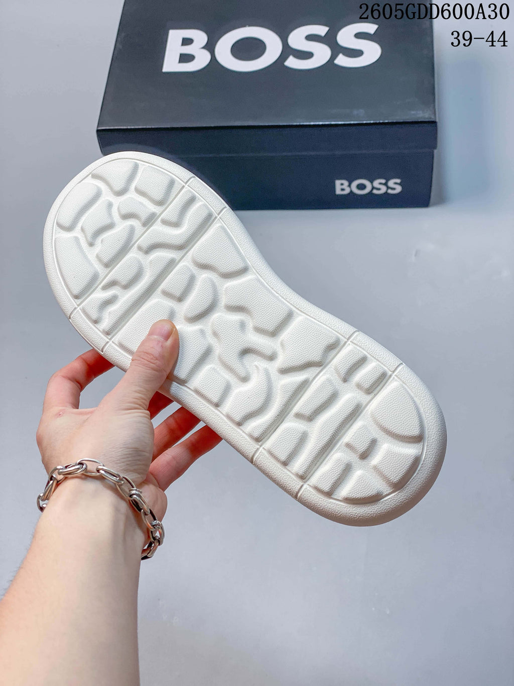 Close-up of the molded tread on the off-white sneaker outsole with a BOSS box in the background; image overlay states sizes 39–44.