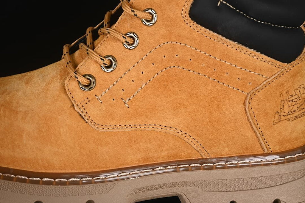 Close-up of the boot's stitched side panels, metal eyelets, and outsole edge