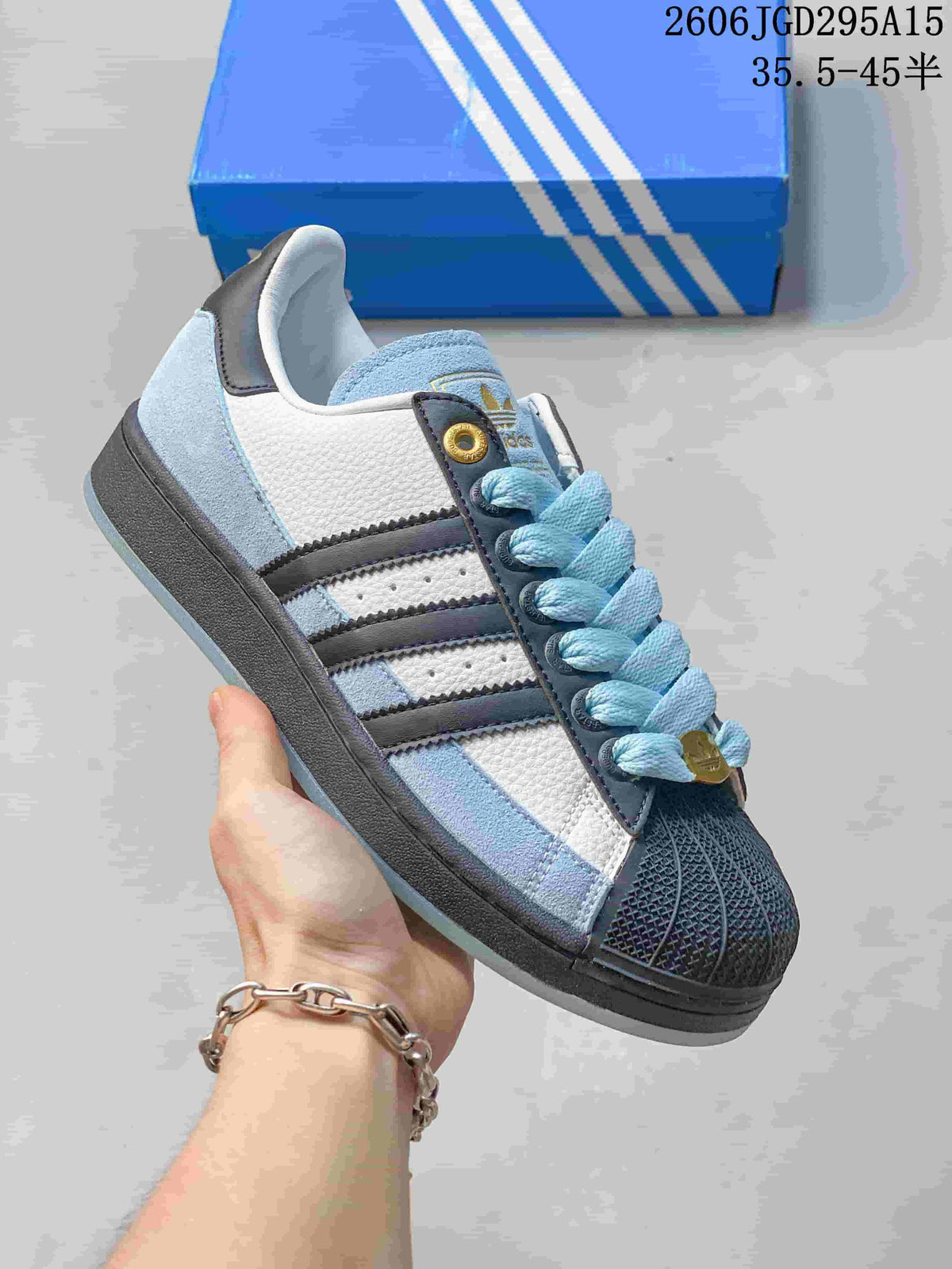 Blue, white, and black Adidas Superstar-style sneaker with a shell toe and blue laces