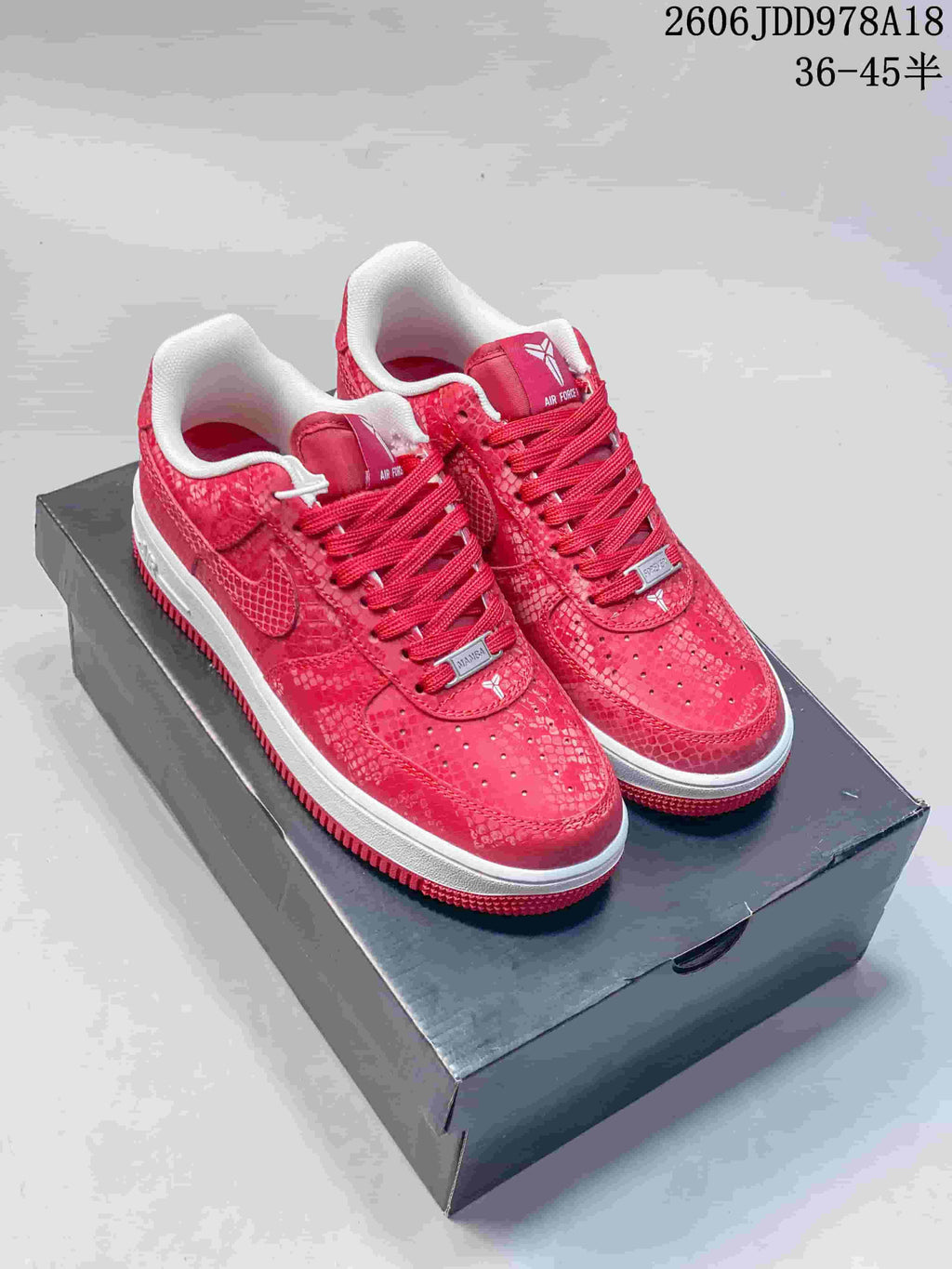 Pair of red patterned Nike Air Force 1 low-top sneakers with white midsoles on a box