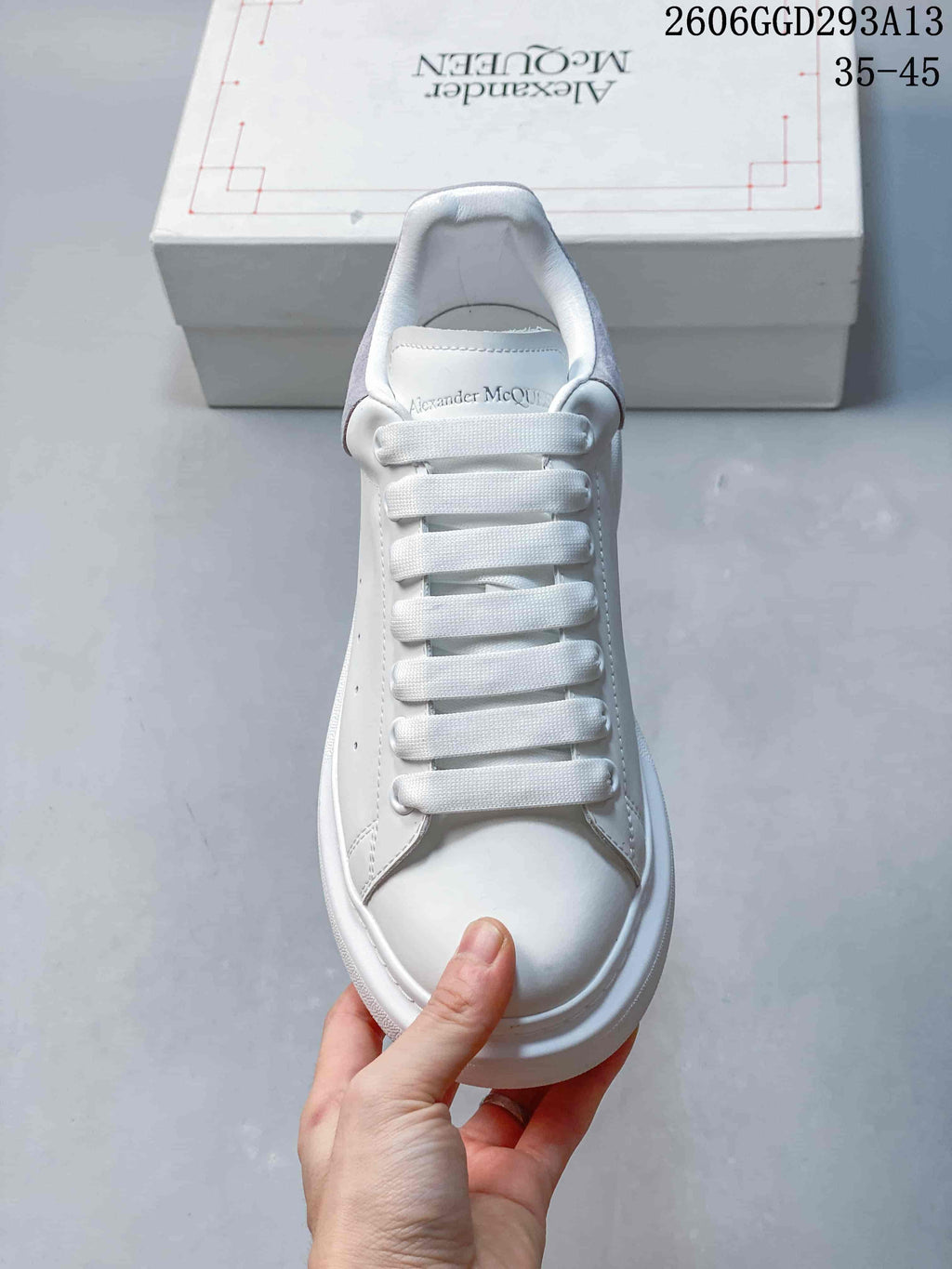 Front view of a white sneaker with broad flat laces