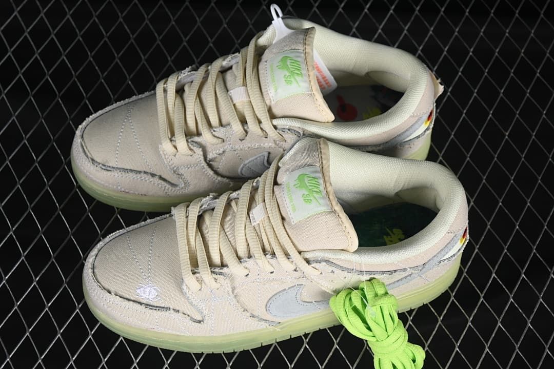 Pair of pale low-top sneakers with bright-green spare laces
