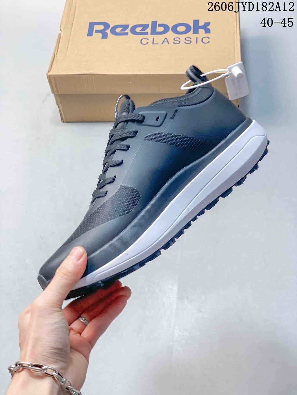 Side profile of a dark gray Reebok sneaker with a white midsole