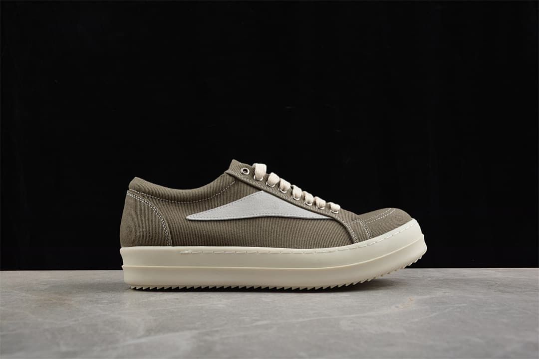 Side profile of a brown canvas low-top sneaker with cream laces and a light-colored side detail