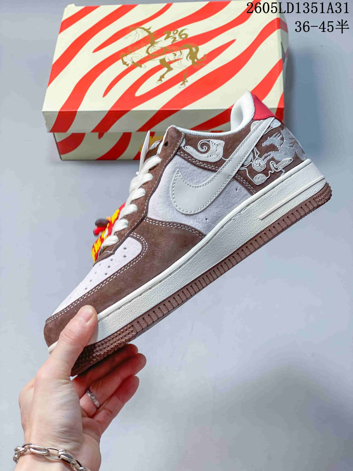 Side view of the low-top sneaker with a white Swoosh, embroidered brown panels, and pale gray upper.
