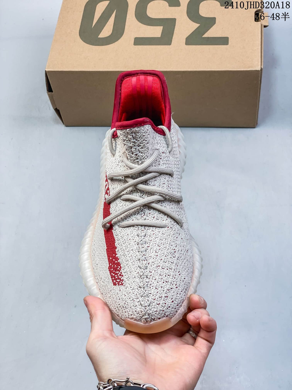 Front view of a cream sneaker with gray laces and red collar lining