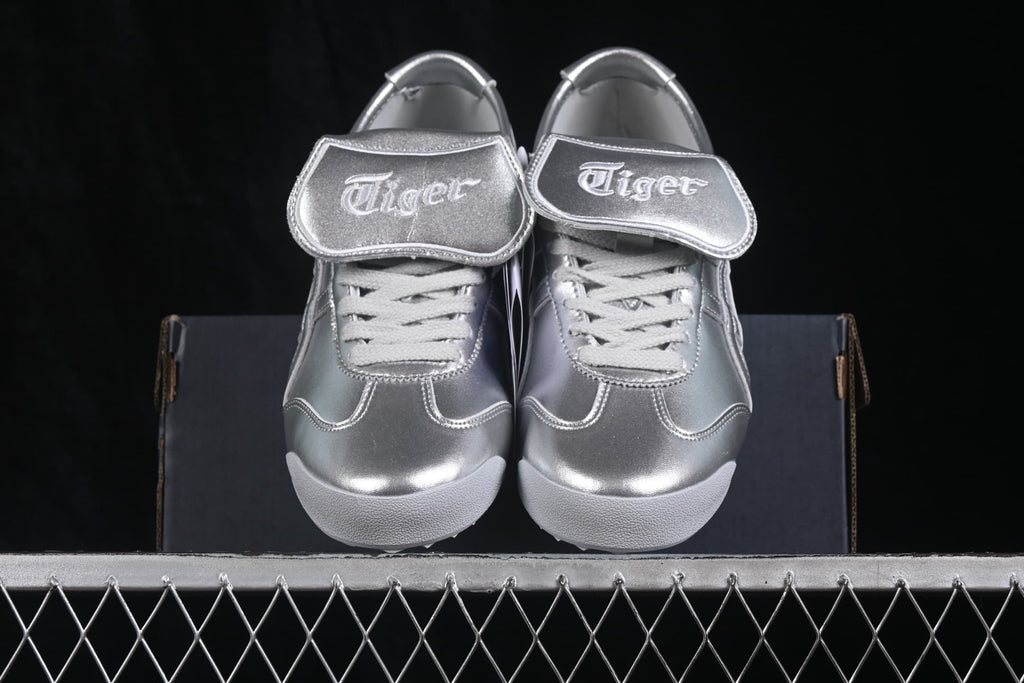 Front view of the silver sneakers showing the branded padded tongues, laces, and rounded toe boxes.