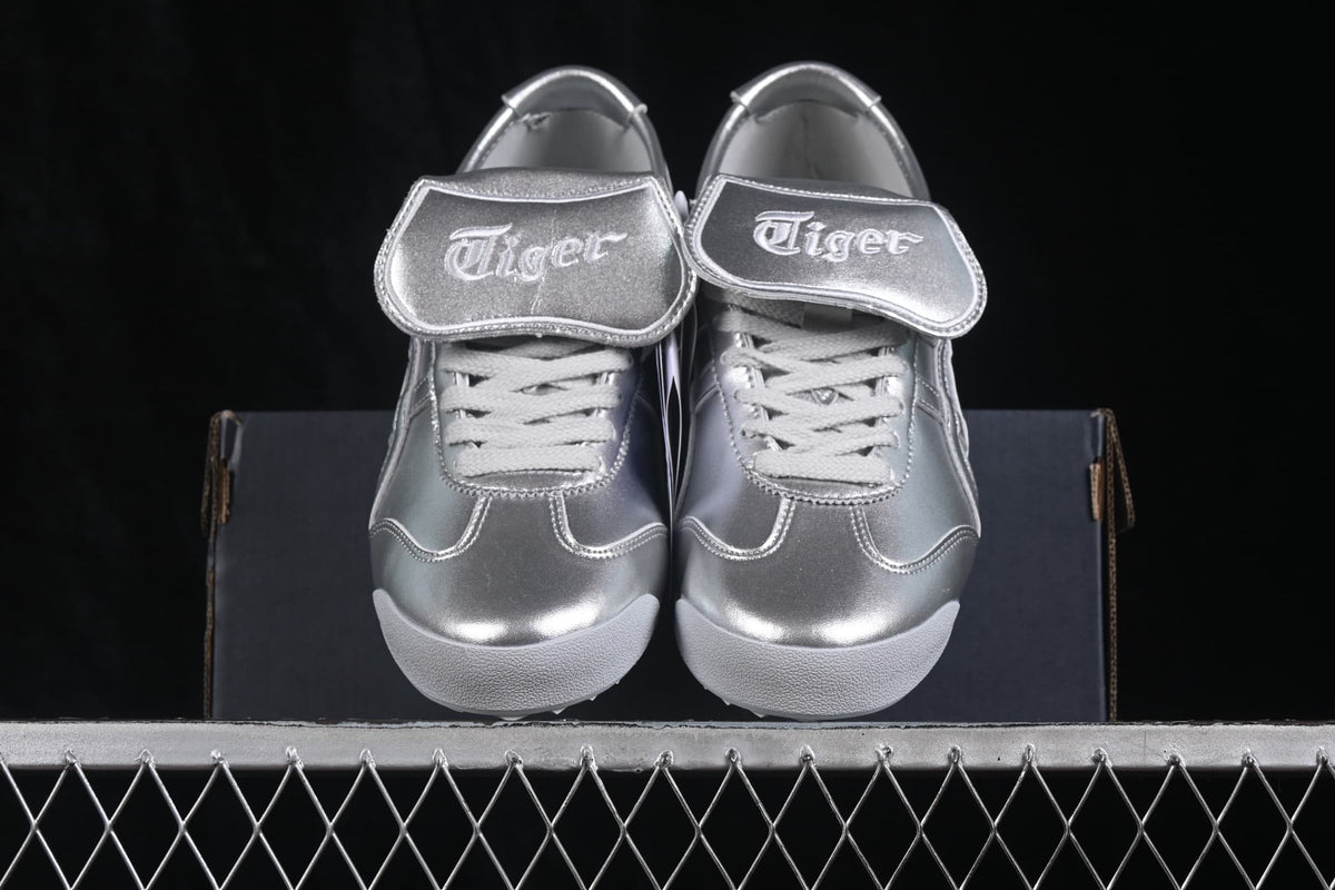Front view of the silver sneakers showing the branded padded tongues, laces, and rounded toe boxes.