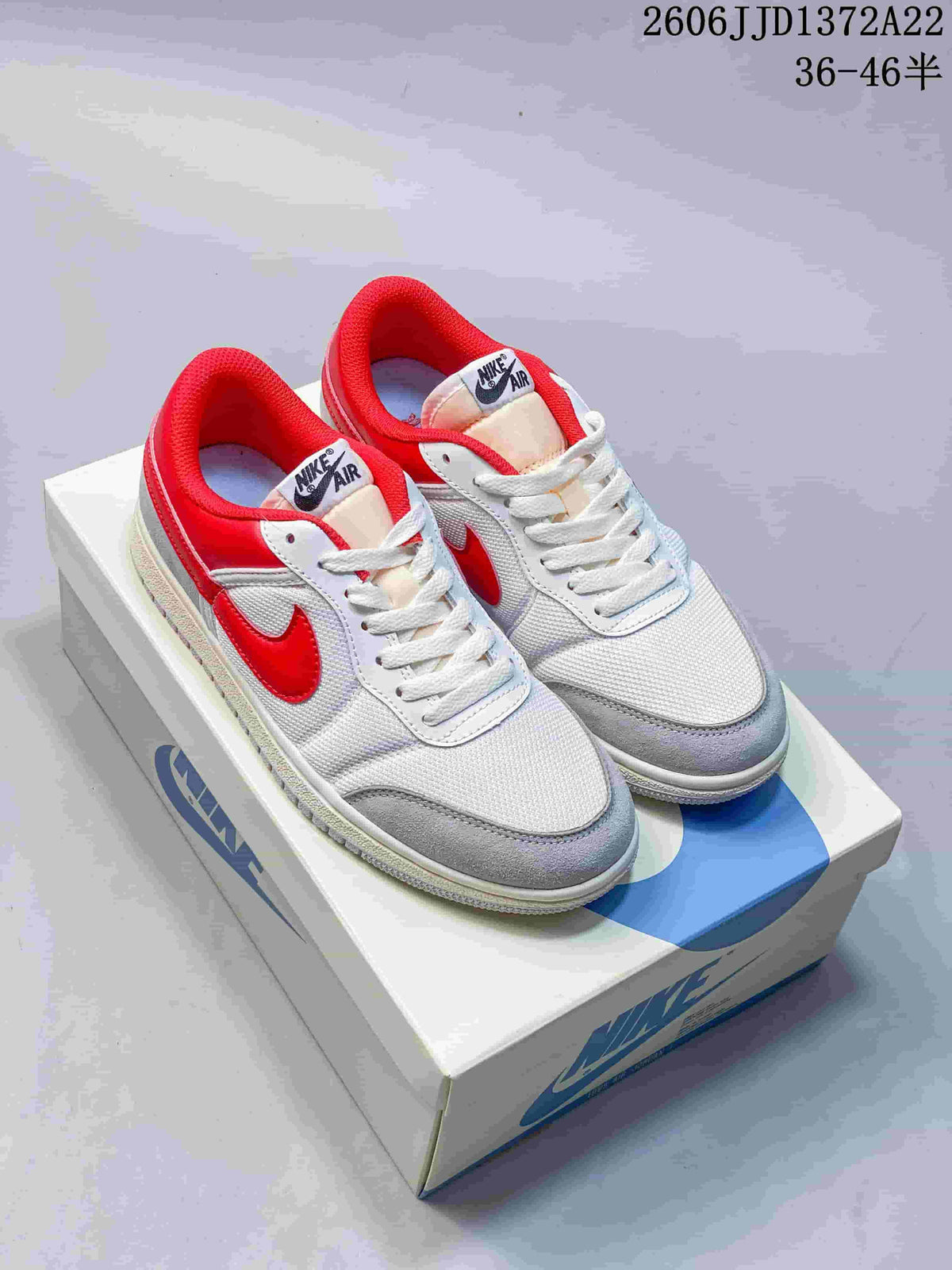 White and gray Nike Air Jordan Skyline low-top sneakers with red accents, pictured on a shoebox.