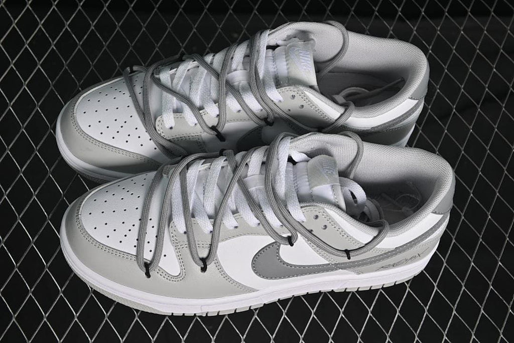 Pair of white and grey low-top sneakers with cord-style lacing