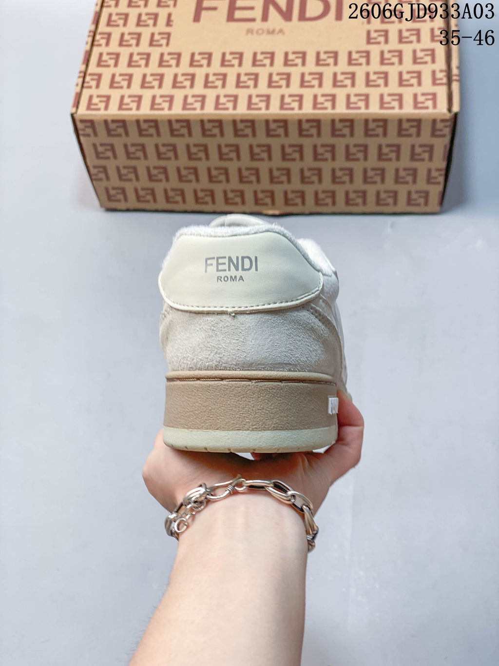 Rear view of a white and beige sneaker with Fendi branding visible on the heel; image overlay shows 2606GJD933A03 and sizes 35–46.