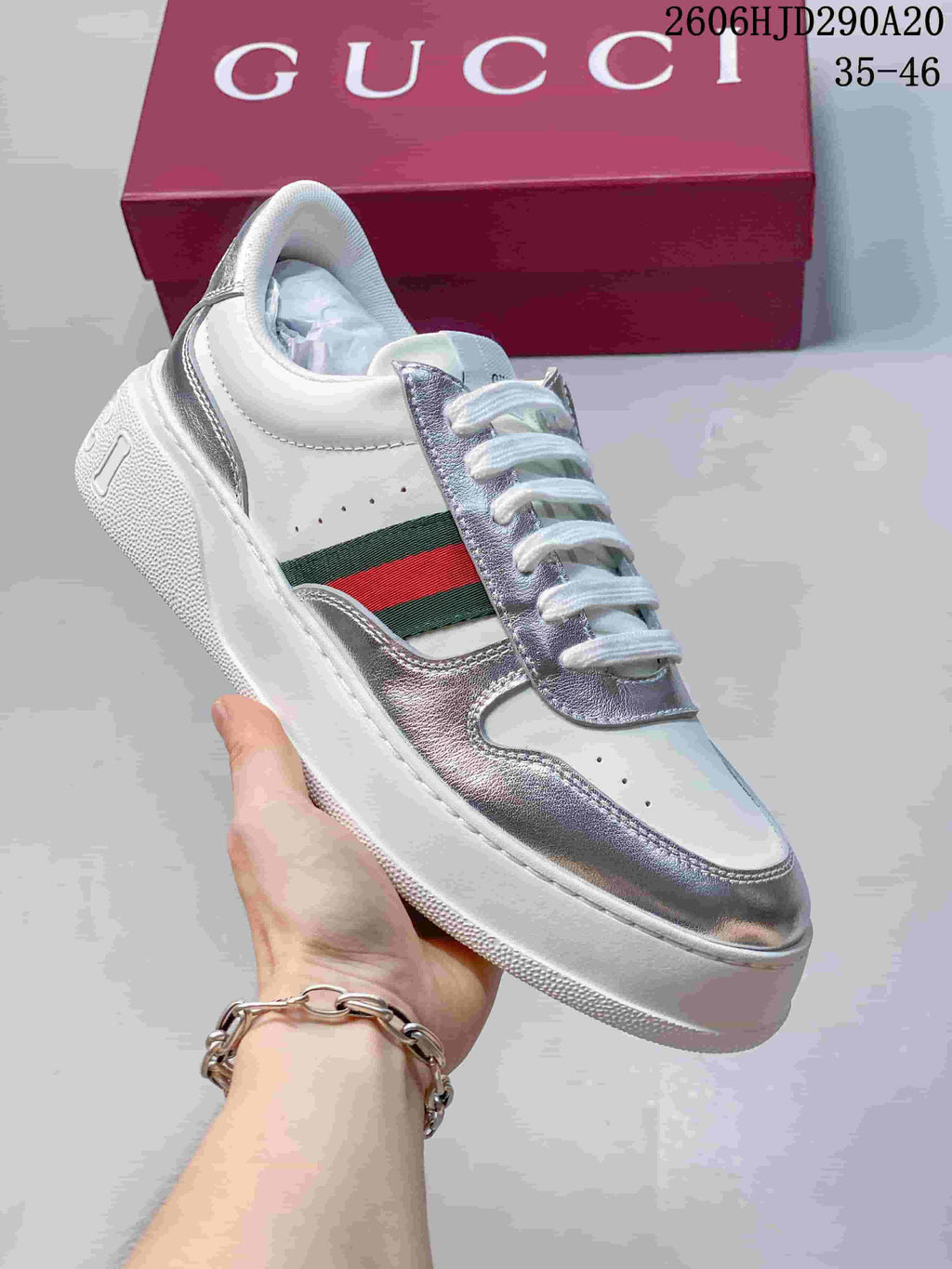 Angled side view of a white and silver low-top lace-up sneaker