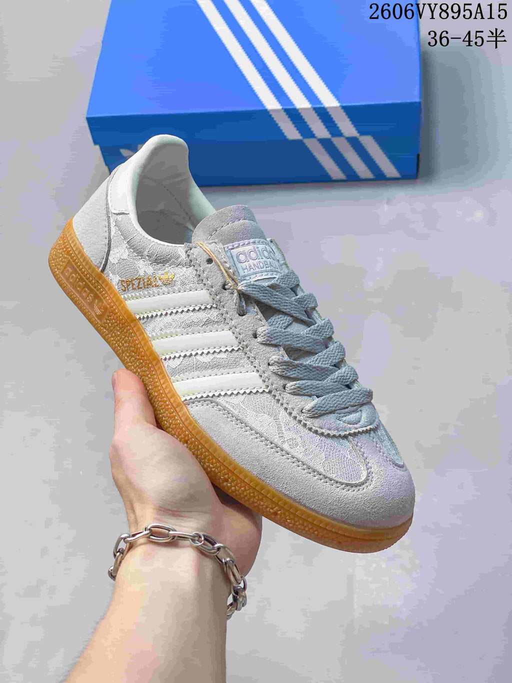 Angled side view highlighting the sneaker's grey and beige tones, three stripes and gum sole