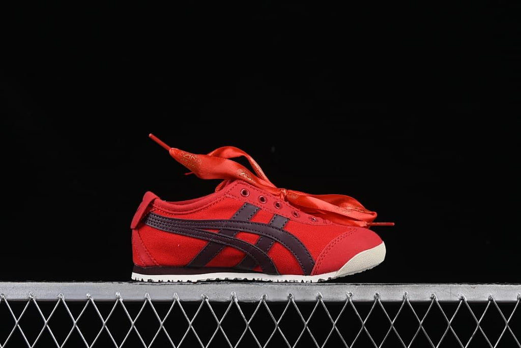 Side profile of the red sneaker with dark stripes and light-colored outsole