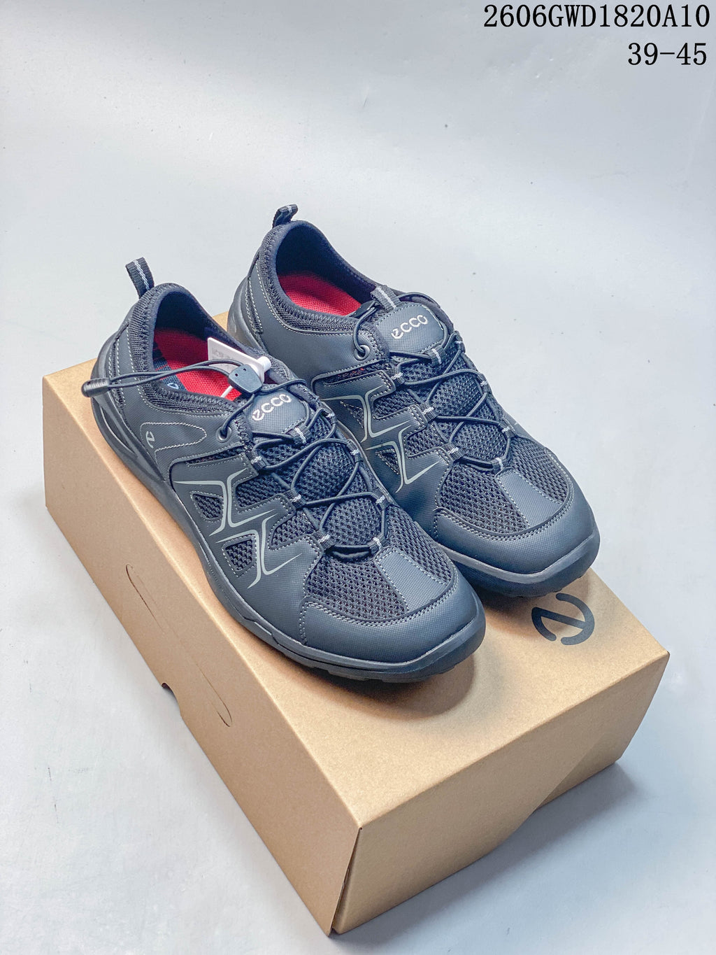 Pair of grey ECCO mesh-panel low-top sneakers displayed on a shoe box; image shows style code 2606GWD1820A10 and a 39–45 size range.