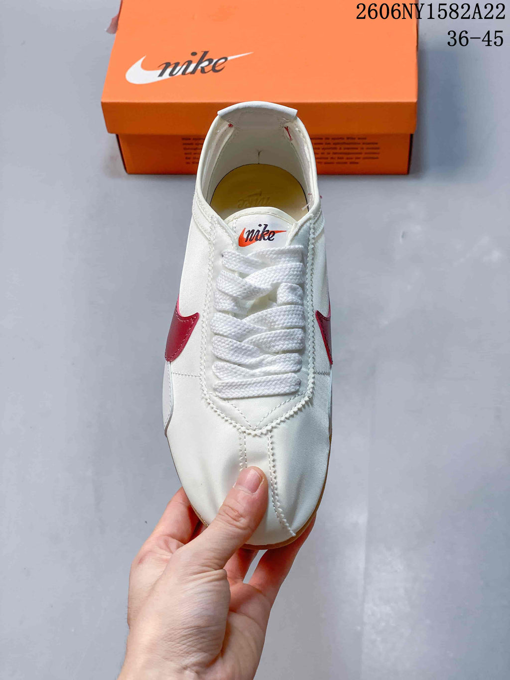 Top view of the sneaker showing the laces, rounded toe, and red side accents.