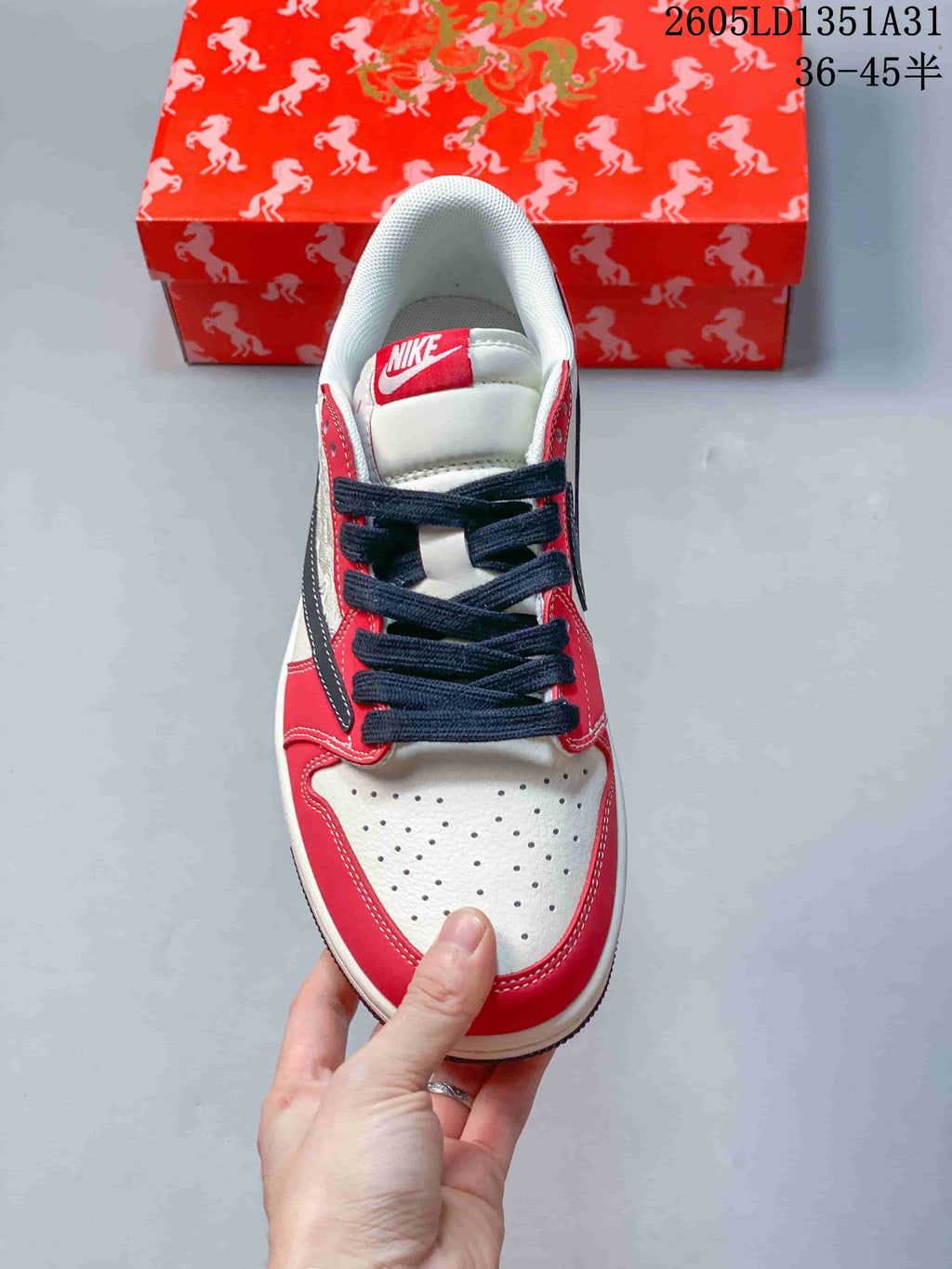 Top view of the perforated white toe, red overlays, and dark laces