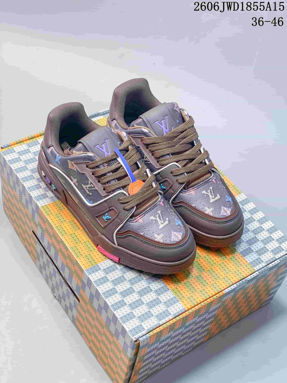 Pair of taupe-toned Louis Vuitton Trainer Low sneakers with multicolor patterned panels and brown laces.