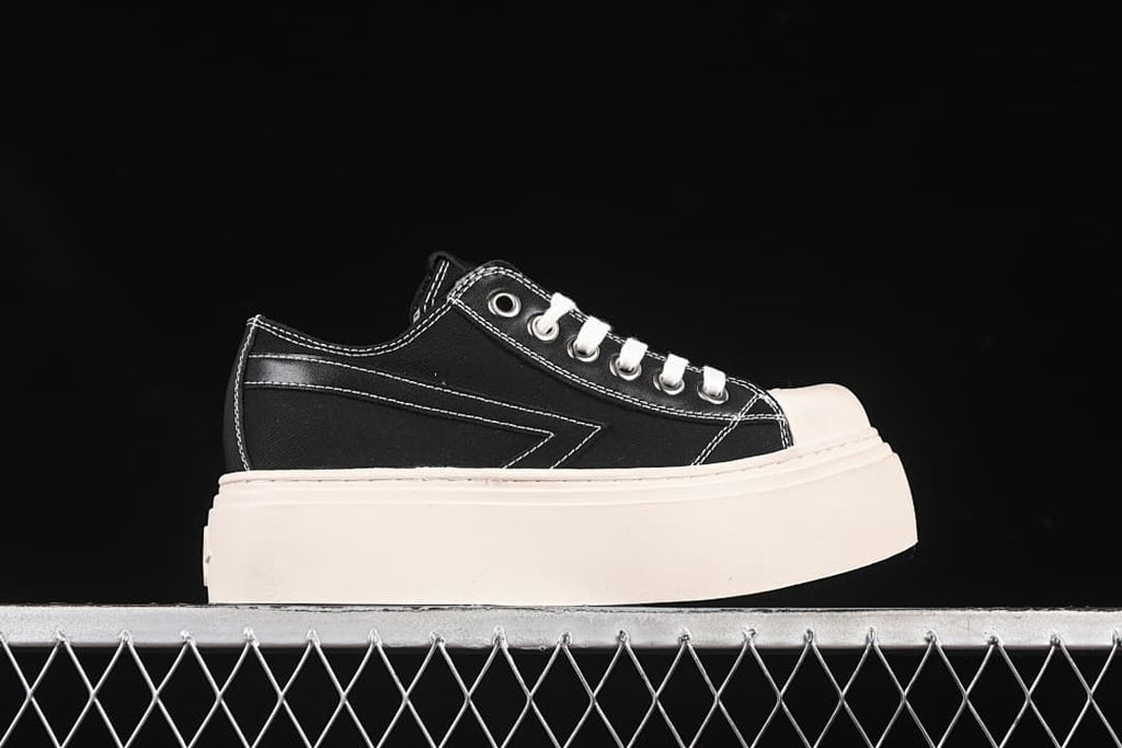 Side profile of a black low-top sneaker with a thick platform sole.