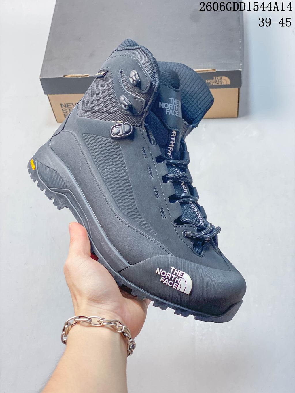 Side view of the dark gray hiking boot with lace hardware and treaded outsole.
