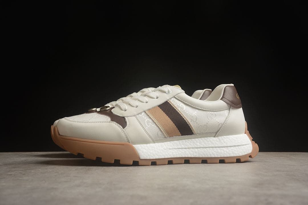 Three-quarter view of the pair of sneakers in ivory, tan, and brown