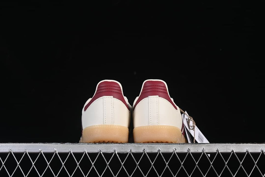 Rear view of both sneakers showing burgundy heel tabs and gum-colored soles.