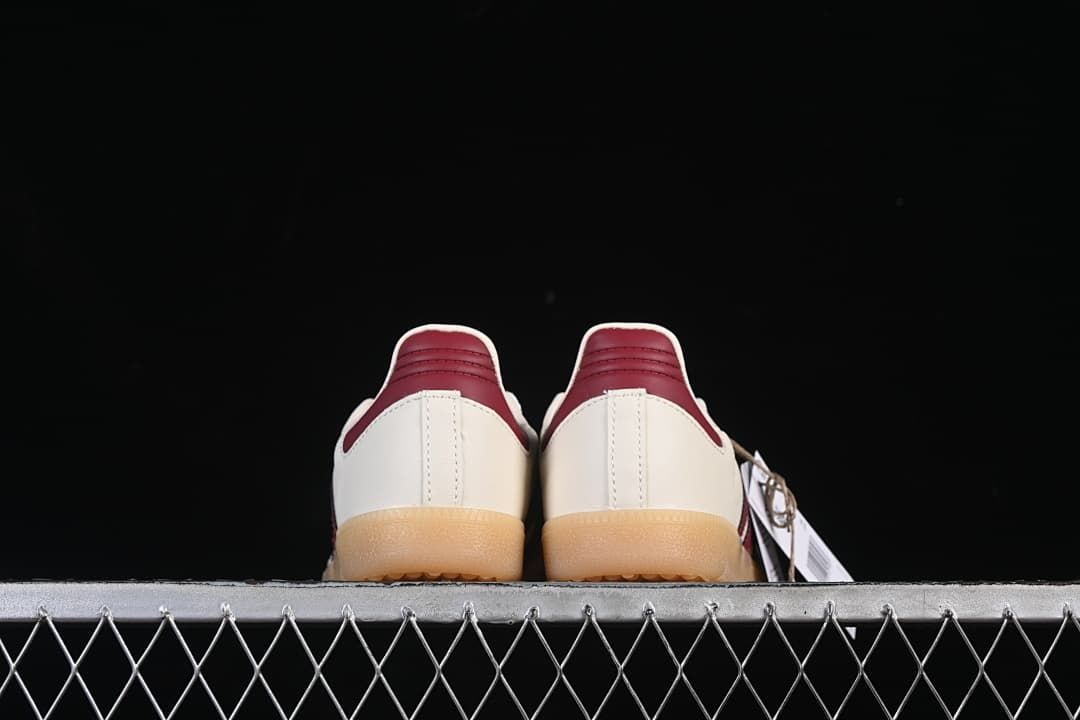 Rear view of both sneakers showing burgundy heel tabs and gum-colored soles.