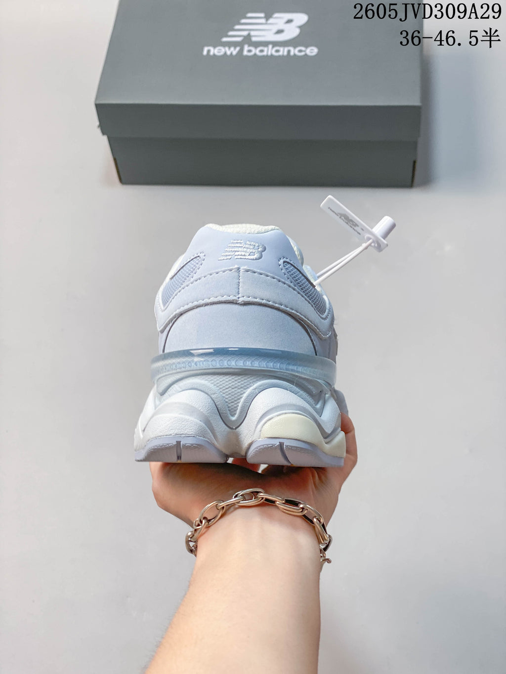 Rear view of a pale blue New Balance 9060 sneaker showing its layered heel and sculpted sole.
