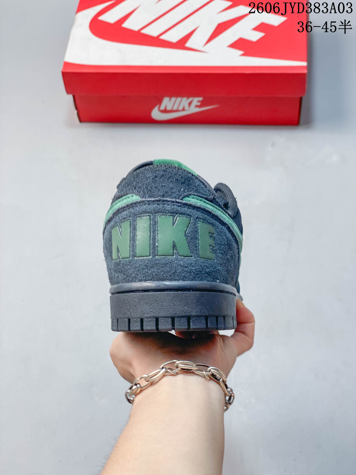 Heel view of the navy sneaker with green Nike lettering