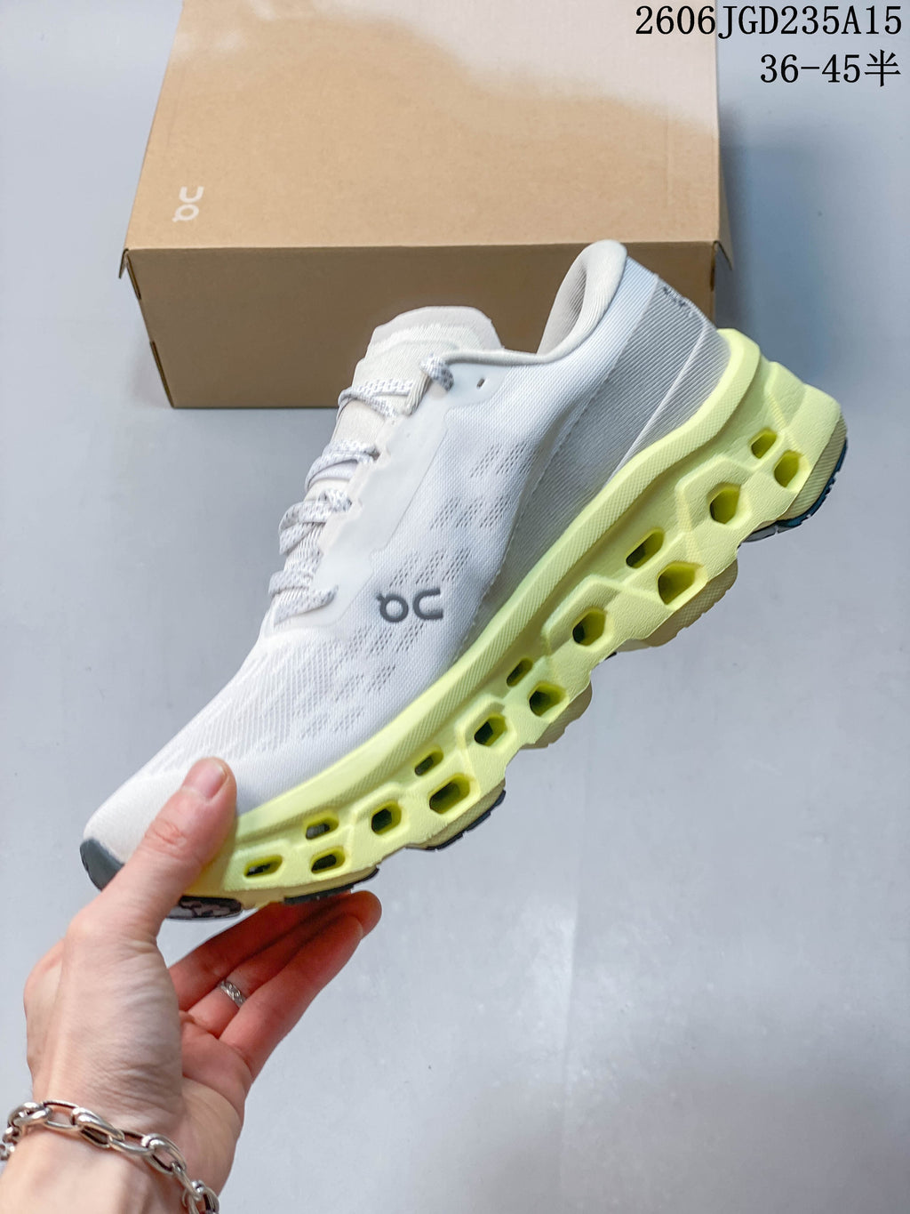 Side view of the white On running shoe with a sculpted pale yellow sole