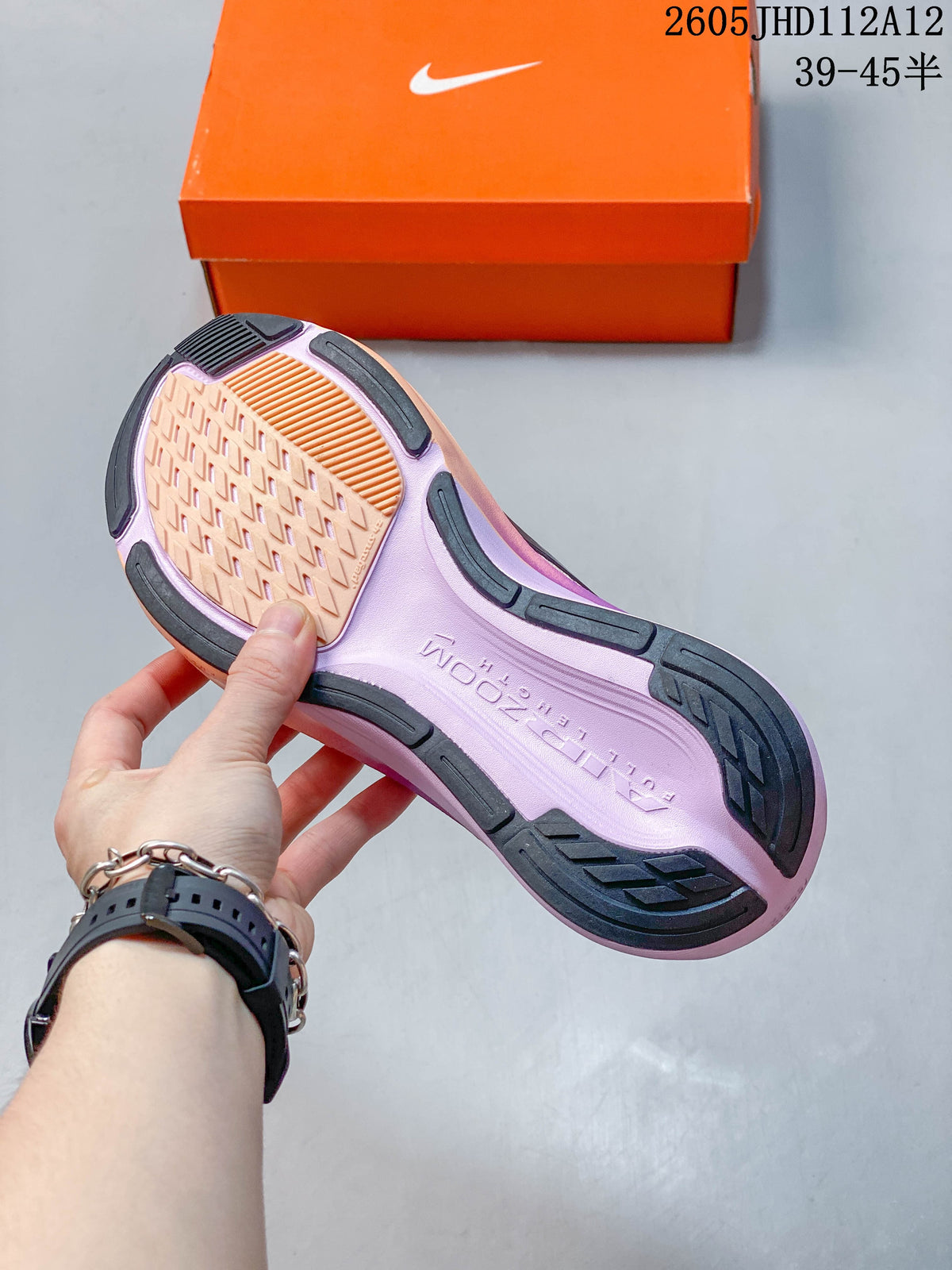 Close-up of the patterned outsole with dark rubber sections and a peach center.