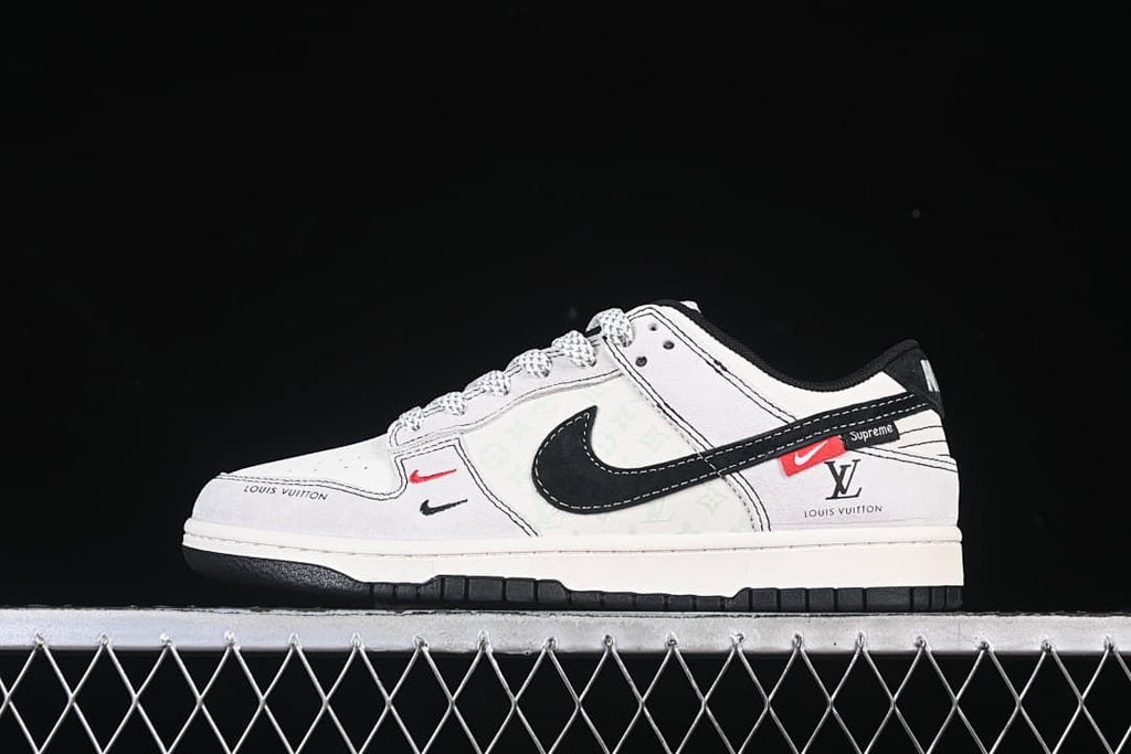 Side view of white and black low-top sneakers with graphic details and red accents