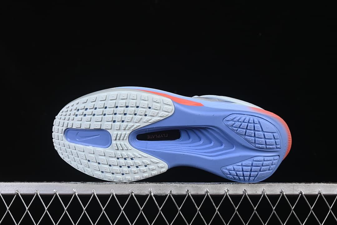 Underside of the shoe showing patterned outsole sections in white and violet.