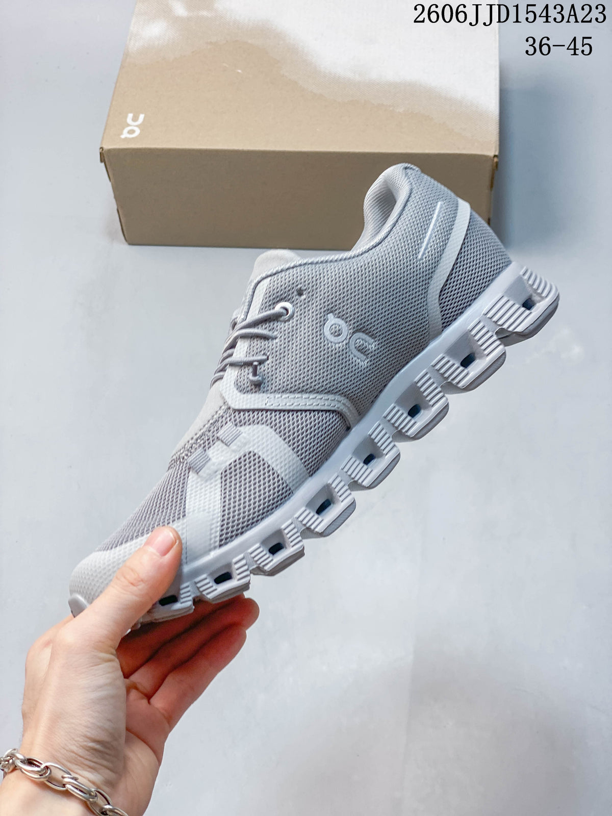 Side view of a grey sneaker with a segmented outsole.