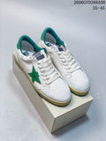 Pair of white Golden Goose Super-Star sneakers with green star details and teal accents