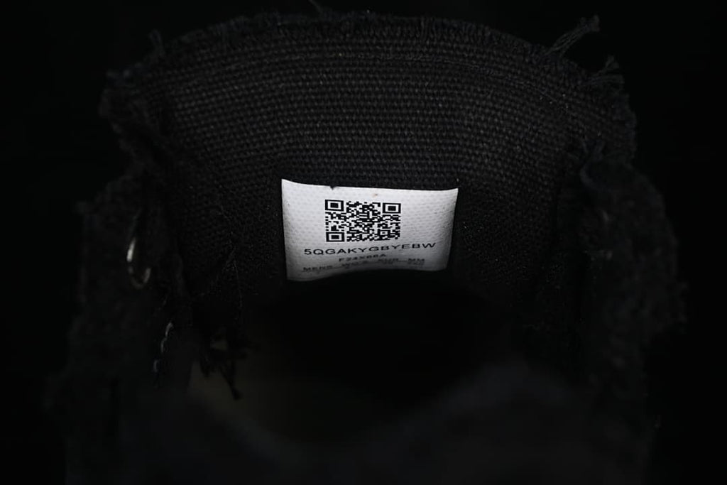 Close-up of the black woven shoe interior and label