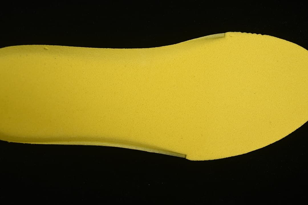 Yellow footbed insert shown separately against a dark background.
