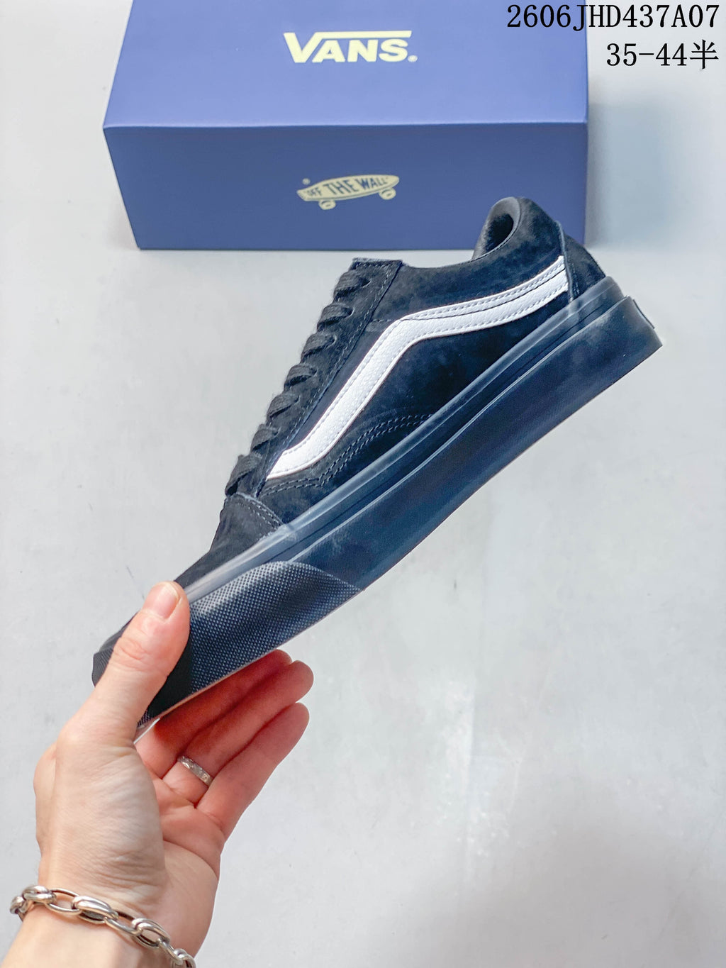 Side profile of the black low-top sneaker with a white side stripe.