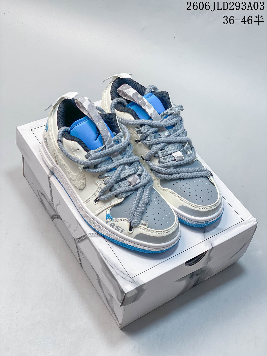 Pair of white, gray, and blue low-top Jordan sneakers on a box