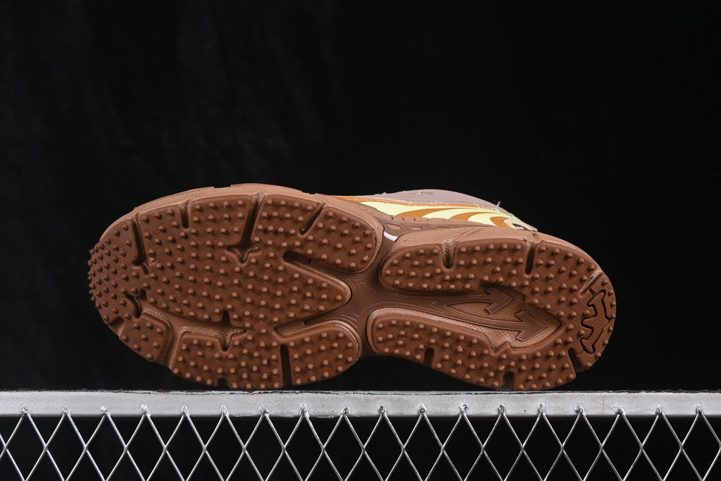 Underside view showing the brown outsole with raised textured tread and segmented traction areas.