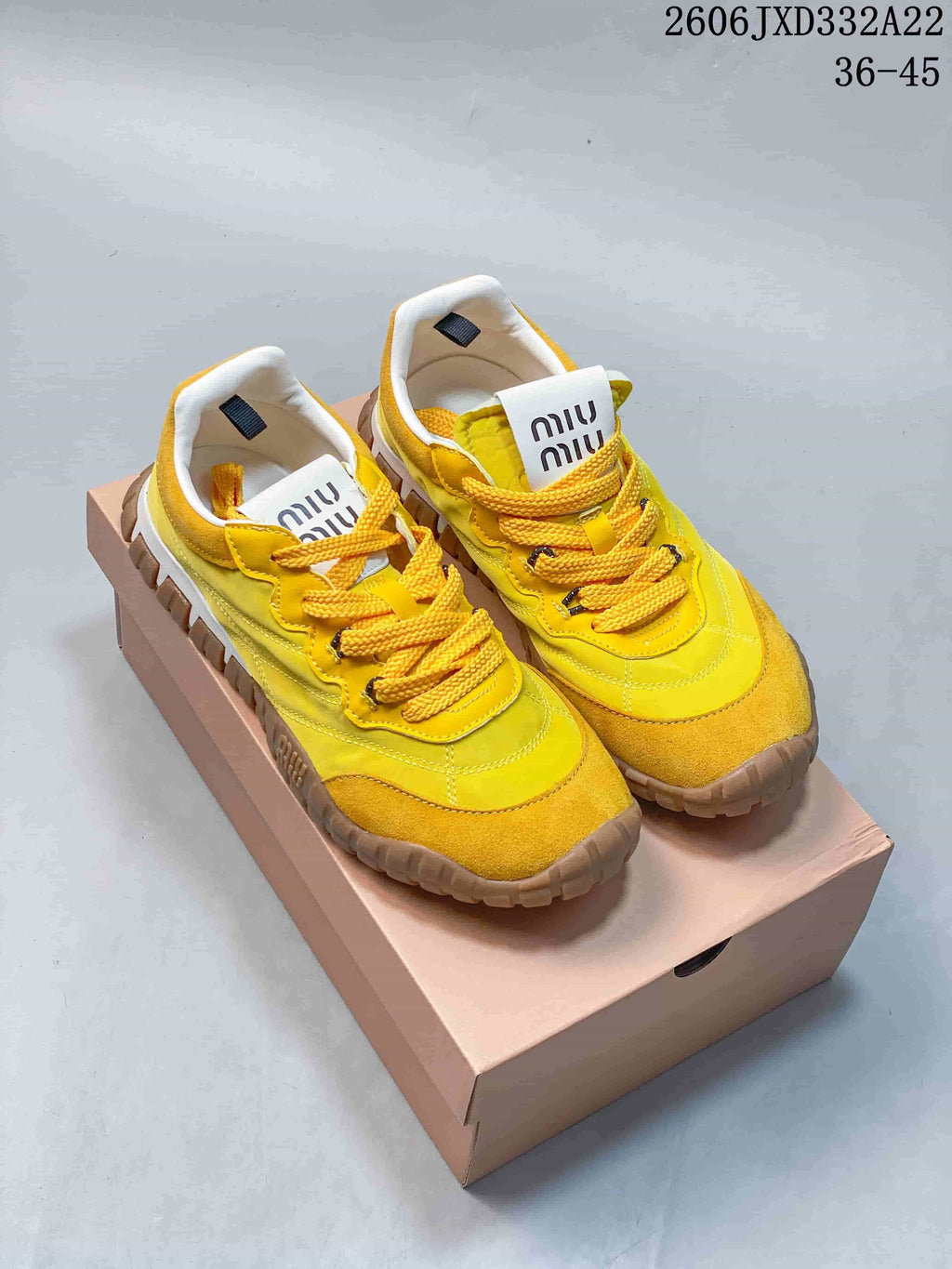 Yellow Miu Miu Tyre low-top sneakers with brown outsole, shown on a box