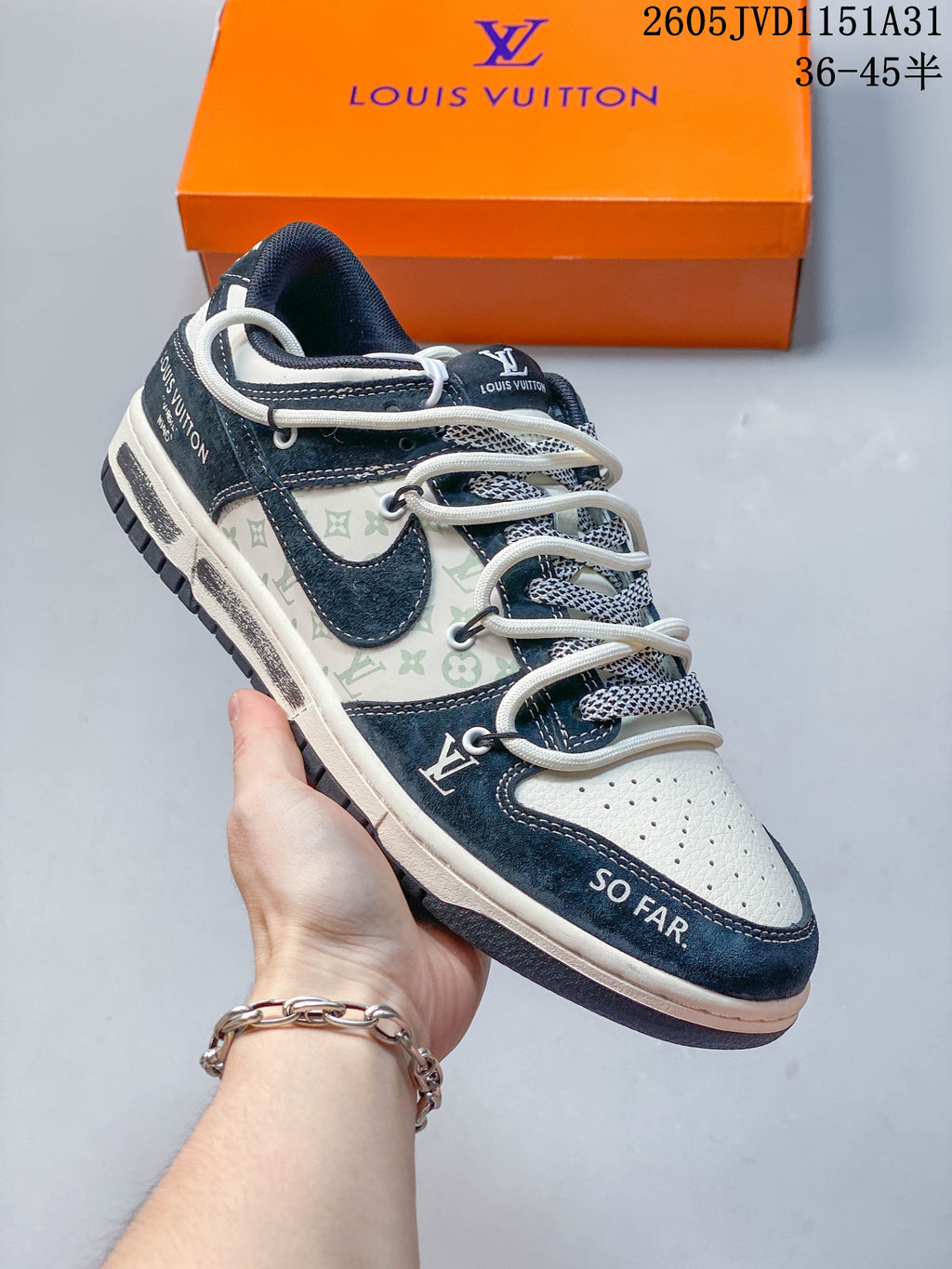 Close view of a cream sneaker with navy overlays, patterned side panels, and layered laces.
