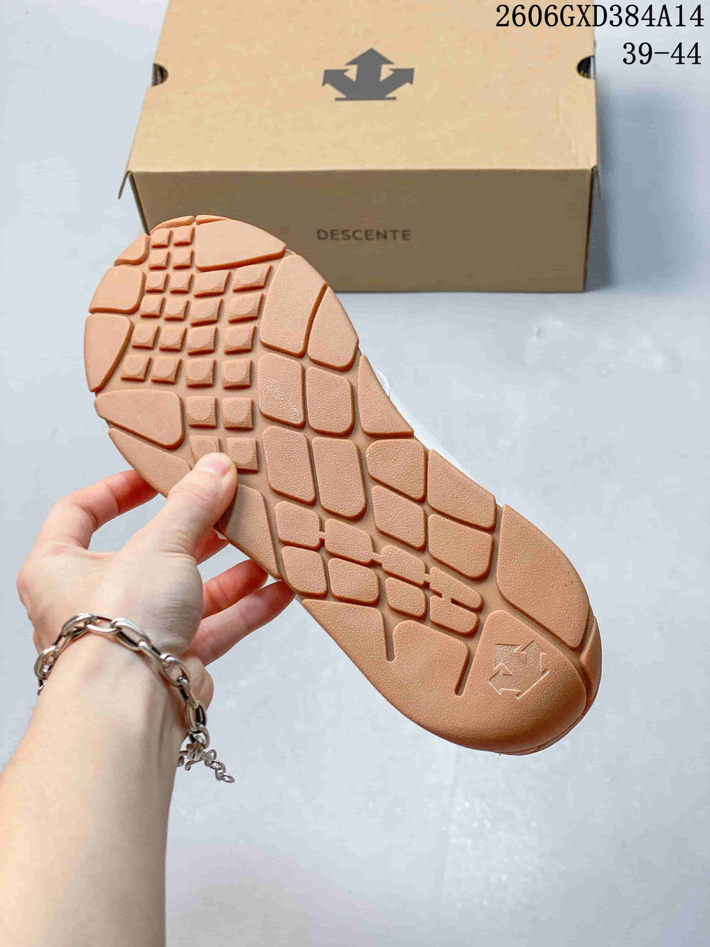 Close-up of the gum-colored outsole tread and Descente shoe box.