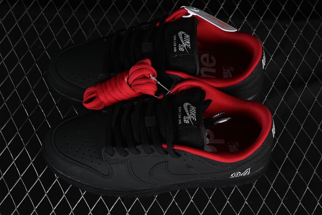 Pair of black low-top sneakers with red lining and an extra red lace set