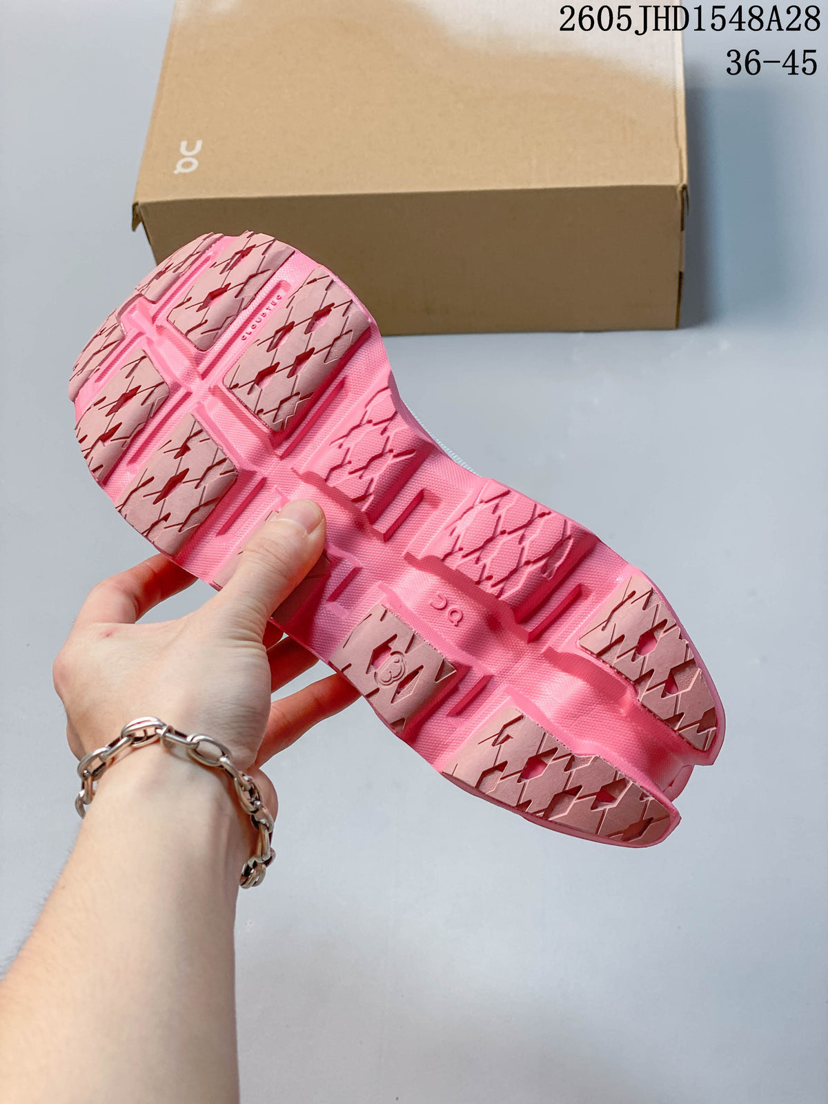 Underside of the shoe showing the pink outsole and segmented tread