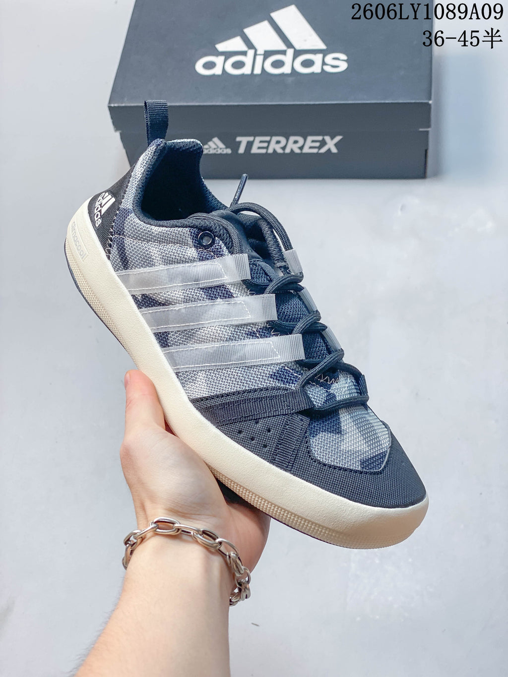 Close-up of a gray graphic Adidas shoe with blue and teal details and a light-colored sole.