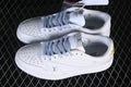 Pair of off-white low-top sneakers with patterned laces, perforated toe panels, embossed motifs, and gold-tone heel details