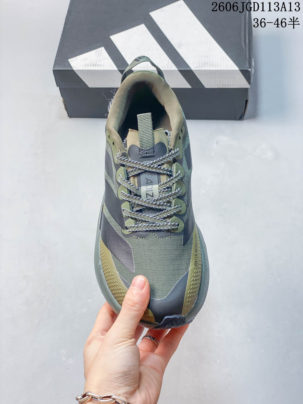 Top view of the laces and upper of an olive running shoe